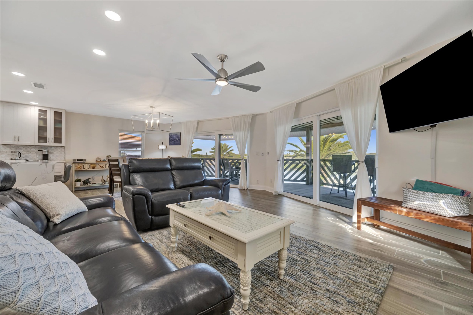 Sink into plush leather seating and let natural light fill your open living space, where palm-fringed balconies invite you to unwind in coastal comfort.