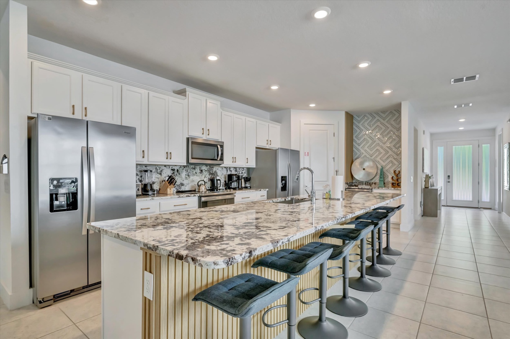 Your chef's kitchen awaits with gleaming granite countertops, stainless steel appliances, and a spacious island with seating—perfect for gathering over morning coffee or evening meals together.