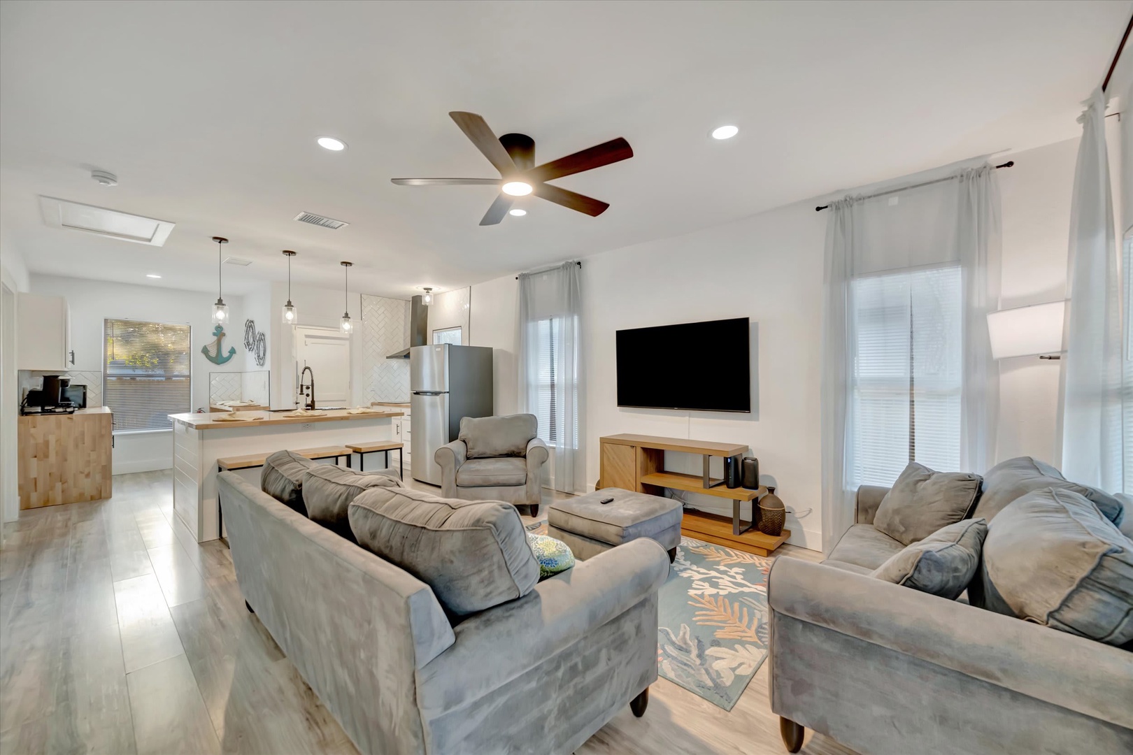 Unwind in your spacious open-concept living area with coastal touches and plush seating—perfect for gathering with loved ones after a day exploring.