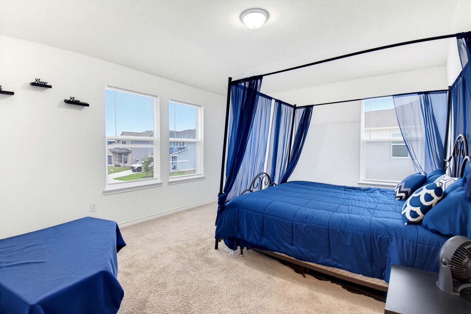 Unwind in your bright and serene bedroom with plush bedding and charming blue accents. Large windows fill the space with natural light while cozy curtains offer privacy when you need it.