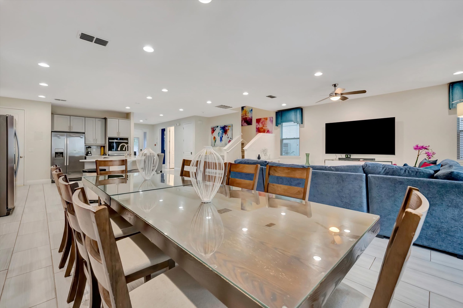 Gather around this sleek dining table with seating for ten, opening to a bright modern kitchen and cozy living space—your perfect setup for shared meals and memorable evenings together.