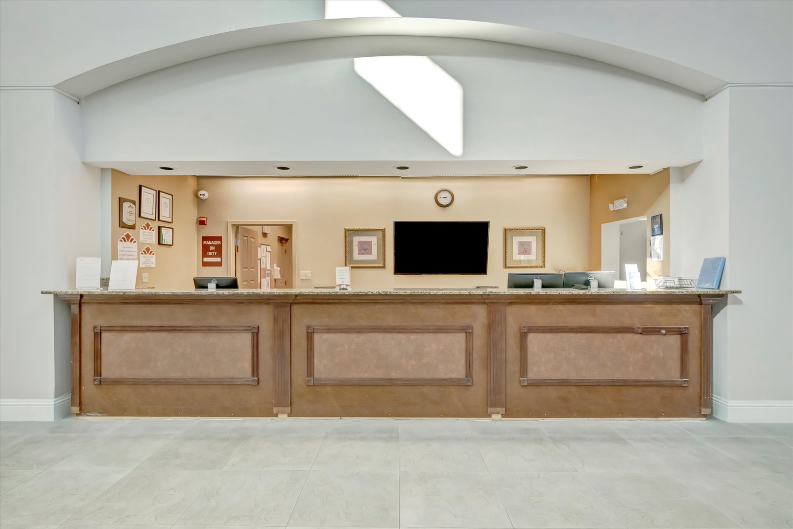 The welcoming reception desk greets you with warm wood tones and an elegant arched entryway, ready to help you settle in quickly.