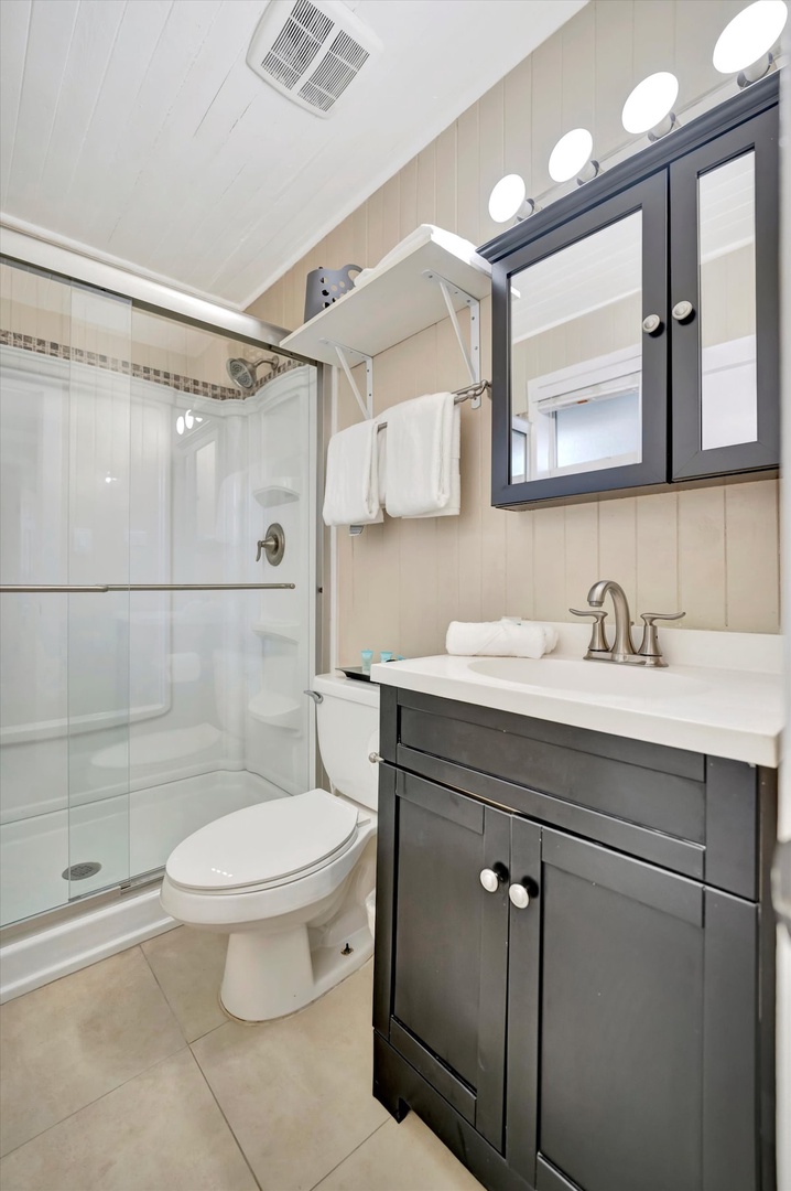 Freshen up in your private bathroom with a spacious walk-in shower, modern vanity, and crisp linens waiting for you.