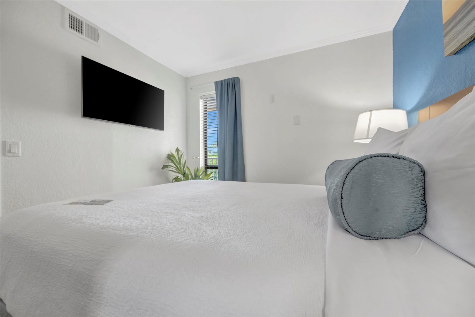 Sink into crisp white linens and let the soothing coastal palette wash over you. Your bedroom offers a peaceful retreat with modern touches and natural light.