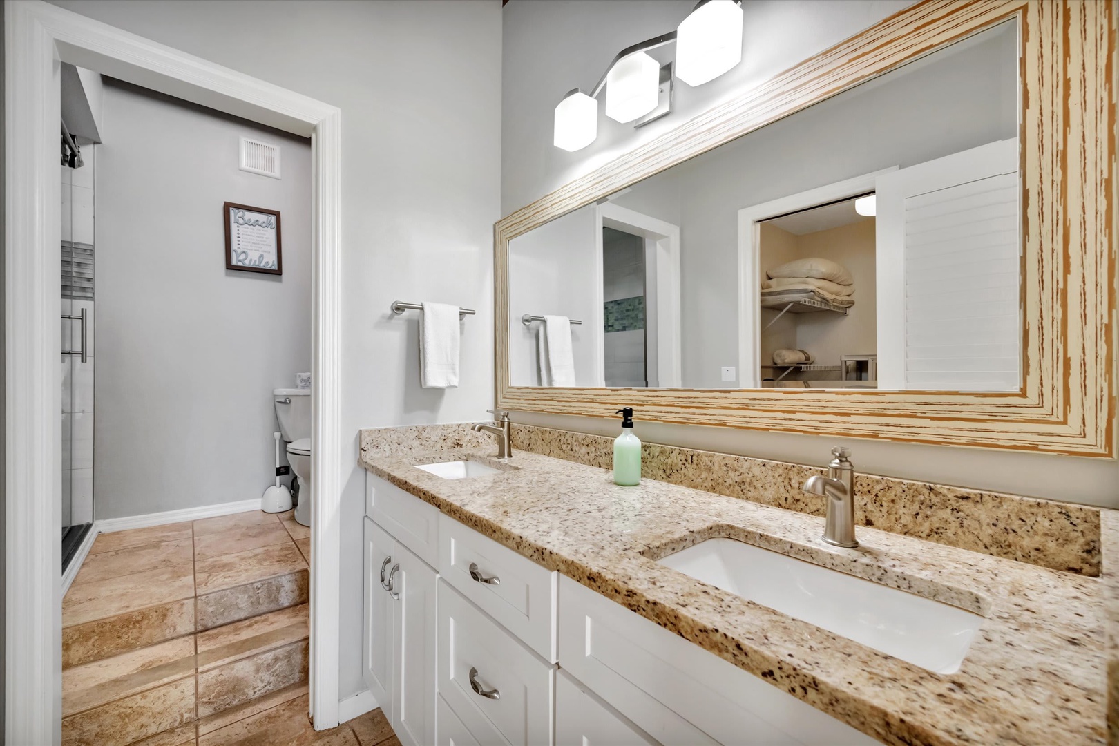 Step into your beautifully appointed bathroom with double sinks, granite countertops, and a spacious glass-enclosed shower. Soft lighting and warm finishes create a calming retreat for your morning routine.