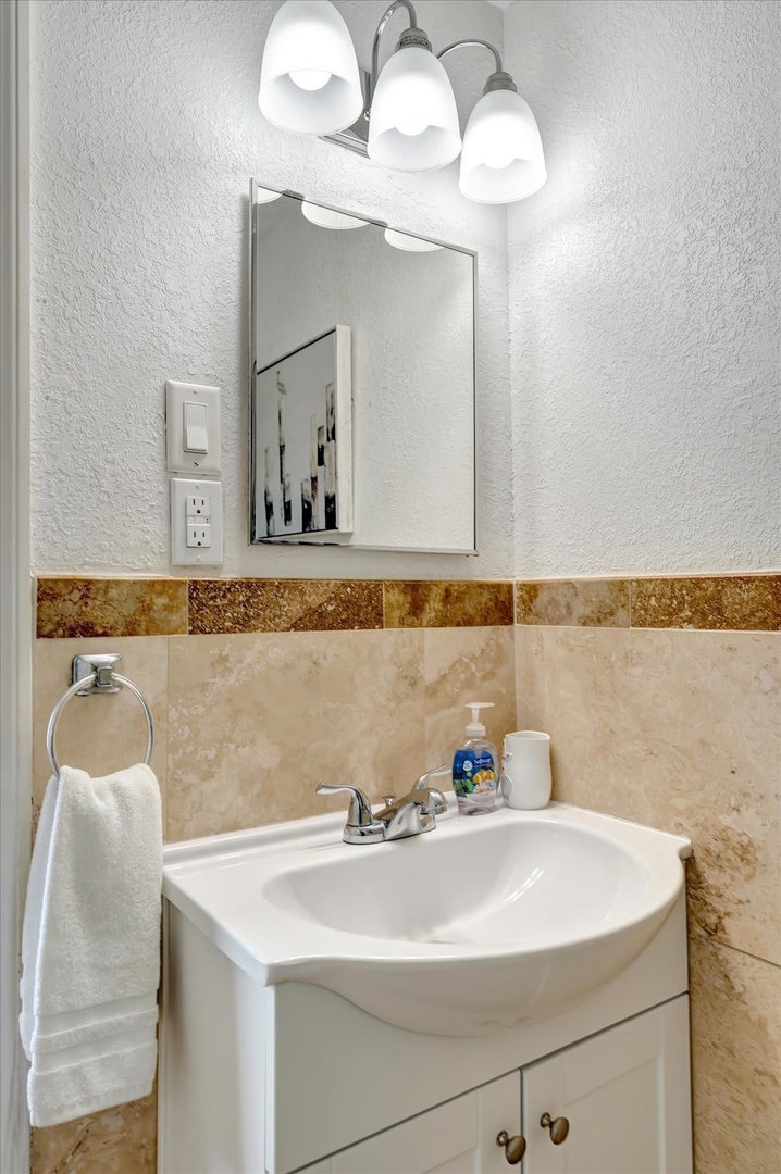 Freshen up in your private bathroom, complete with soft lighting, warm tile accents, and fluffy towels waiting for you.