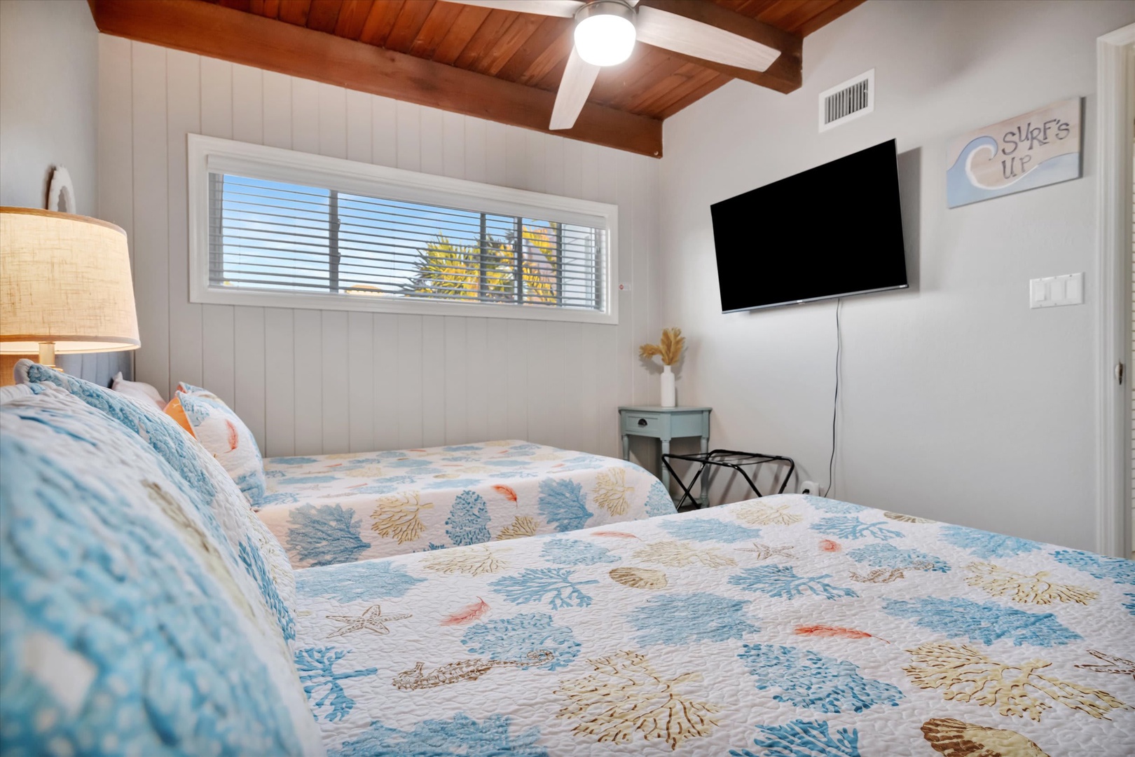 Slip beneath the coastal-inspired quilts and let the warm glow from the natural wood ceiling beams make you feel instantly at home in your serene retreat.