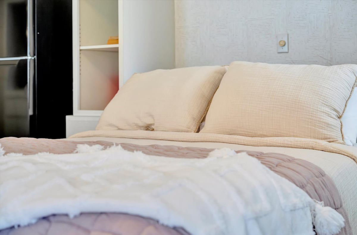 Sink into plush pillows and soft linens in your serene bedroom retreat, where every detail invites you to unwind and recharge.