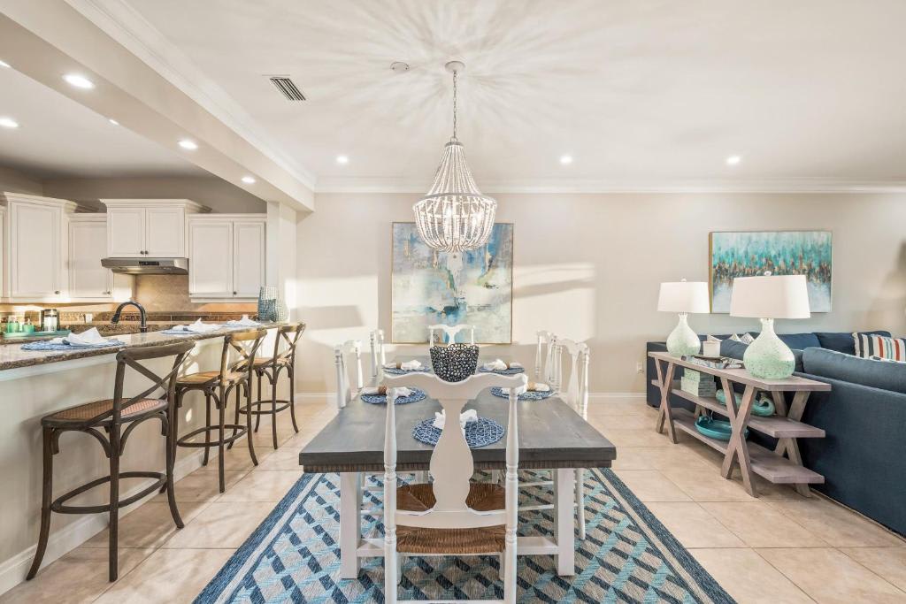 Step into your bright, open-concept living space where coastal elegance meets everyday comfort. The airy layout invites you to relax, cook, and gather with loved ones under soft lighting and a charming chandelier.