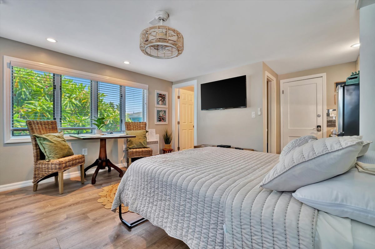 Sink into plush bedding and wake up to lush tropical views through your windows. A cozy seating nook invites you to enjoy morning coffee while soaking in natural light.