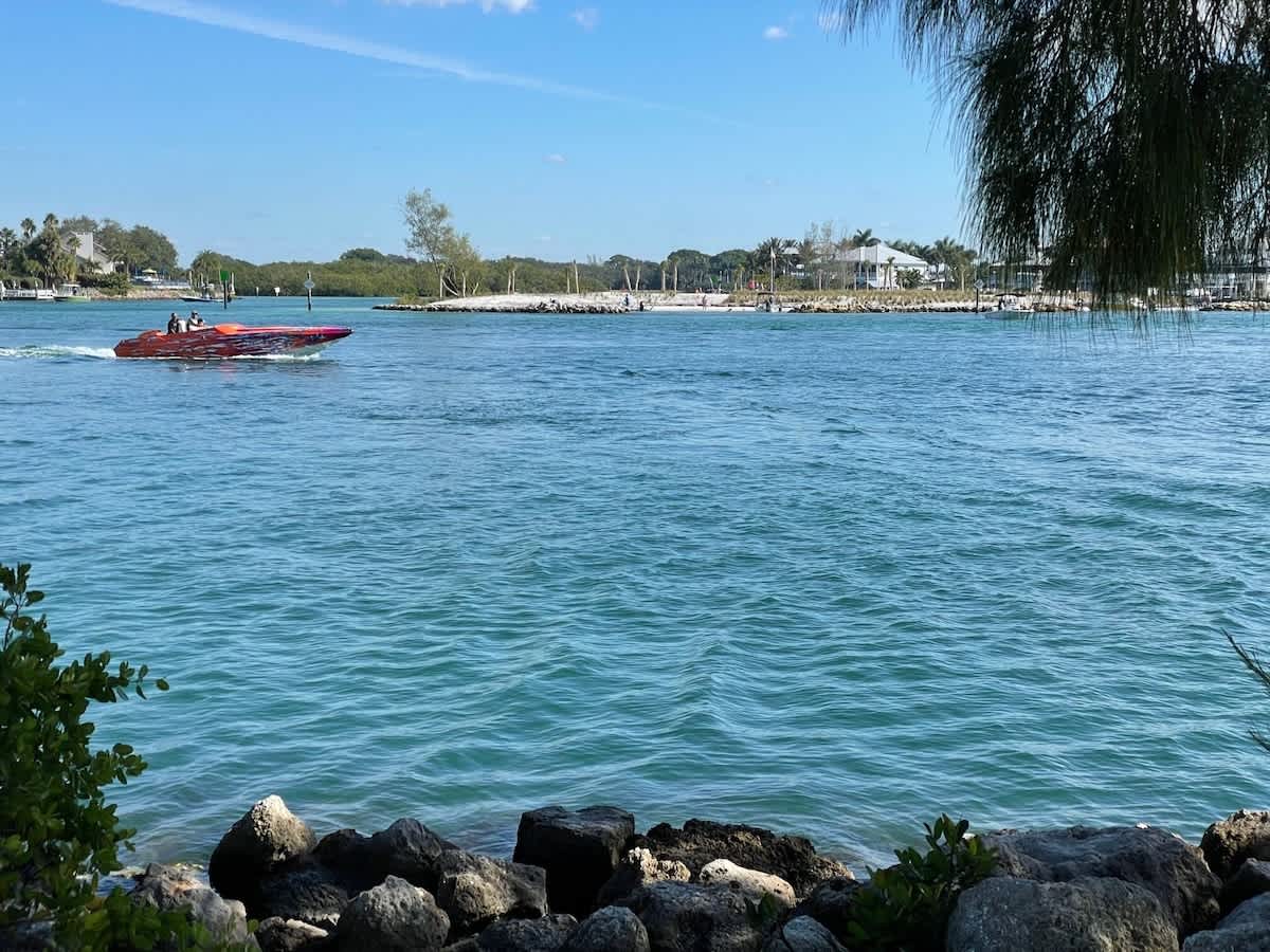 The property sits along calm, turquoise waterfront waters, offering boating access and scenic natural shoreline as part of the surrounding area.