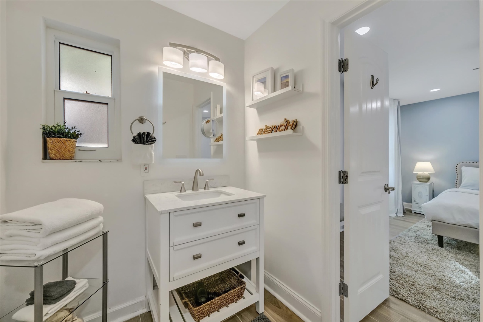 Step into your bright, spa-like bathroom where crisp white finishes and soft lighting create a calming retreat. Fresh towels await, and coastal touches add charm to your morning routine.