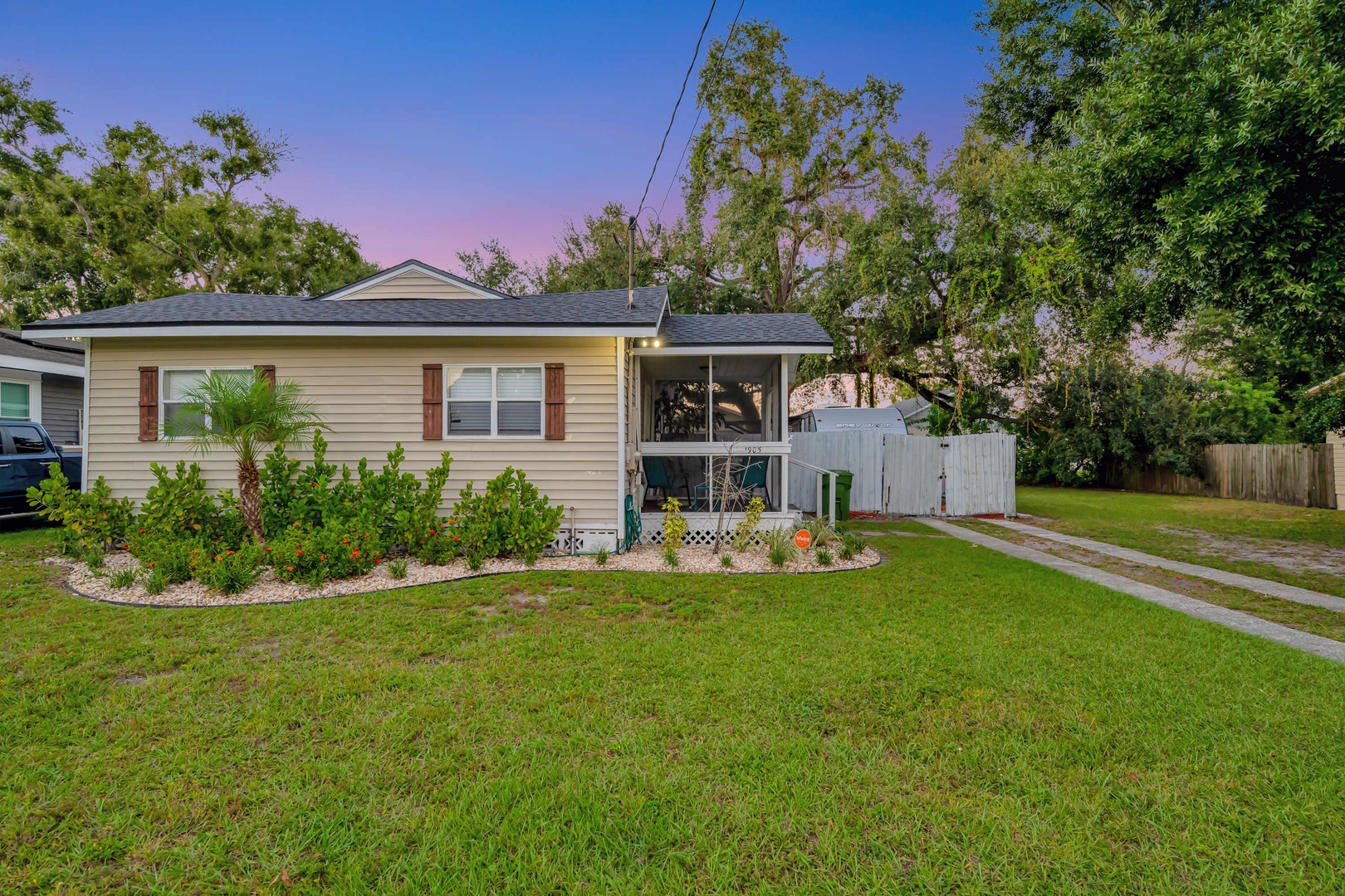 This inviting property features a spacious yard with tropical landscaping and mature trees, perfect for relaxing in your own private outdoor oasis.