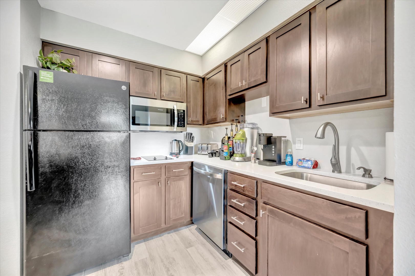 Your fully equipped kitchen makes meal prep a breeze, with warm wood cabinetry, stainless appliances, and a skylight that floods the space with natural light.