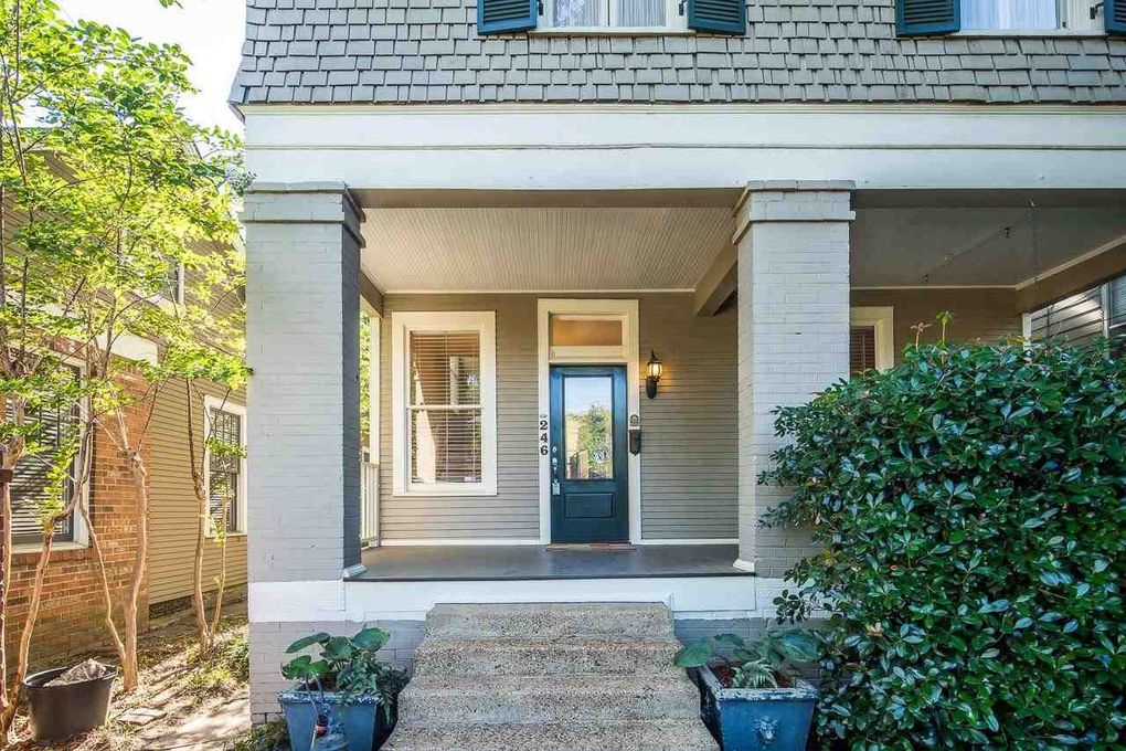 This welcoming front entrance features classic architectural details with a covered porch, elegant dark door, and lush greenery framing your arrival. The thoughtfully designed facade sets the tone for your stay.