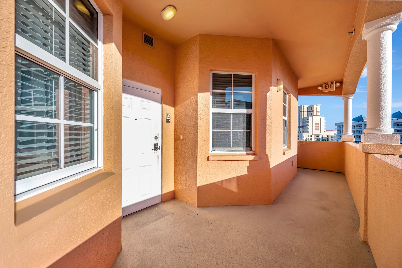 Private outdoor entrance corridor leading to your unit, with warm terracotta tones and clean, modern finishes that welcome you home after a day of exploring.