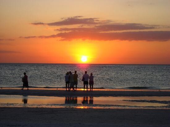 Golden hour at the beach as the sun dips below the horizon, painting the sky in warm hues of orange and amber—a perfect backdrop for evening strolls along the shore.
