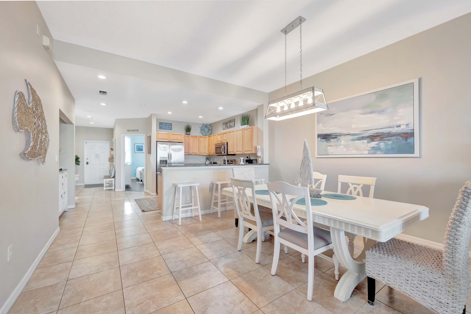 Gather around the spacious dining table for meals and conversation, with an open kitchen and bright, coastal-inspired décor that invites you to feel right at home.