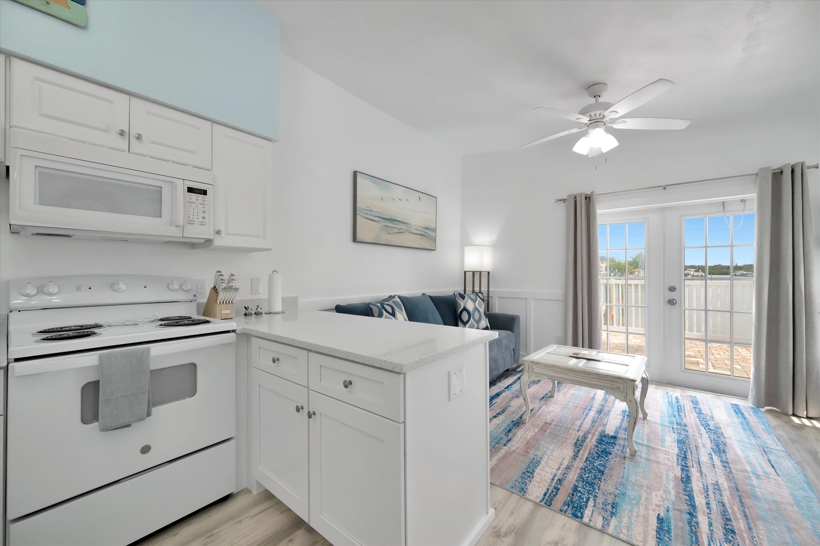 Your open-plan retreat blends kitchen and living space in soothing coastal tones, with a full stove, microwave, and dishwasher for easy meal prep. Step through the glass doors to your private balcony and soak in the natural light.