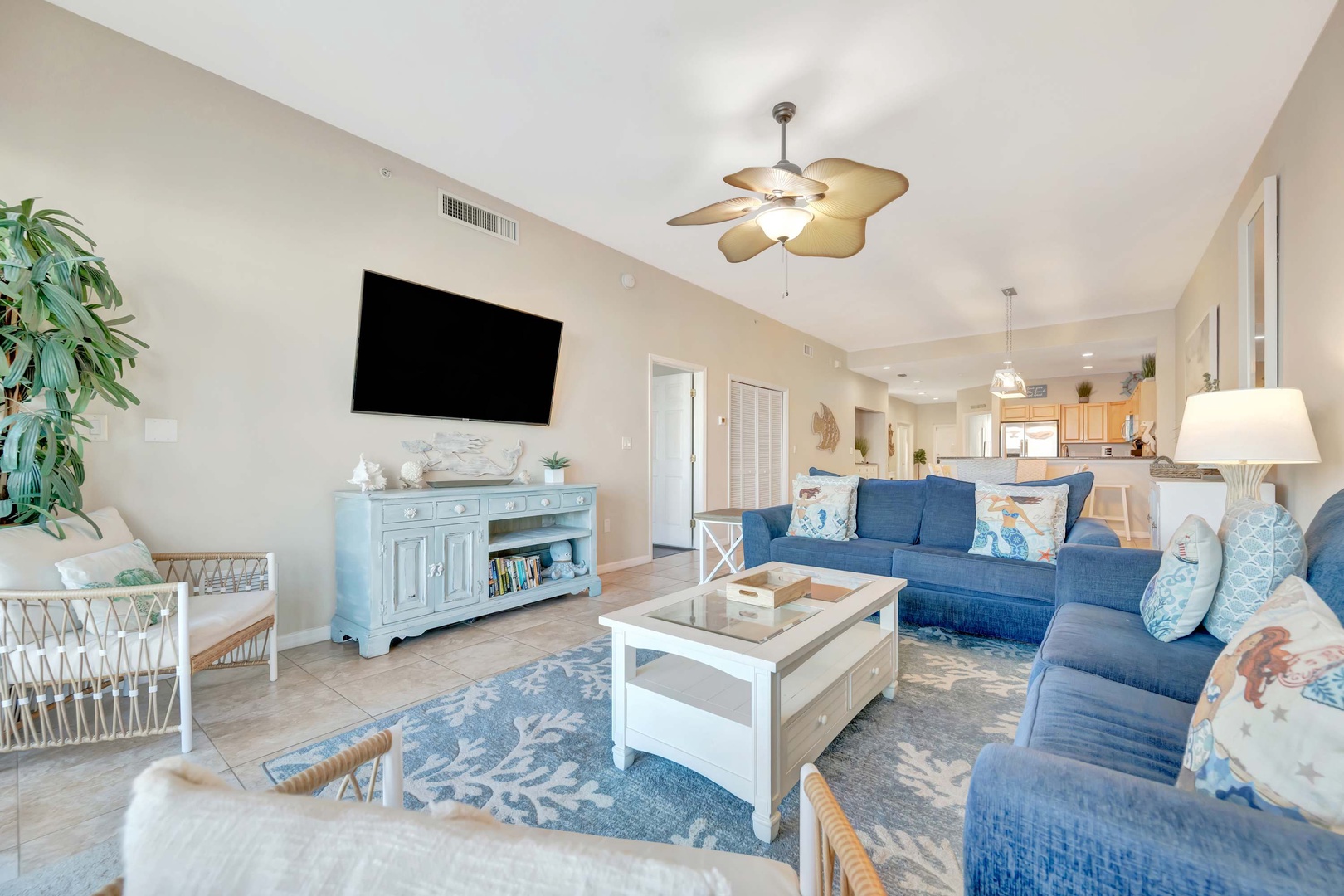 Settle into your bright, coastal-inspired living room where soft blues meet airy comfort. The open layout flows seamlessly into the kitchen, perfect for easy conversation while you relax.