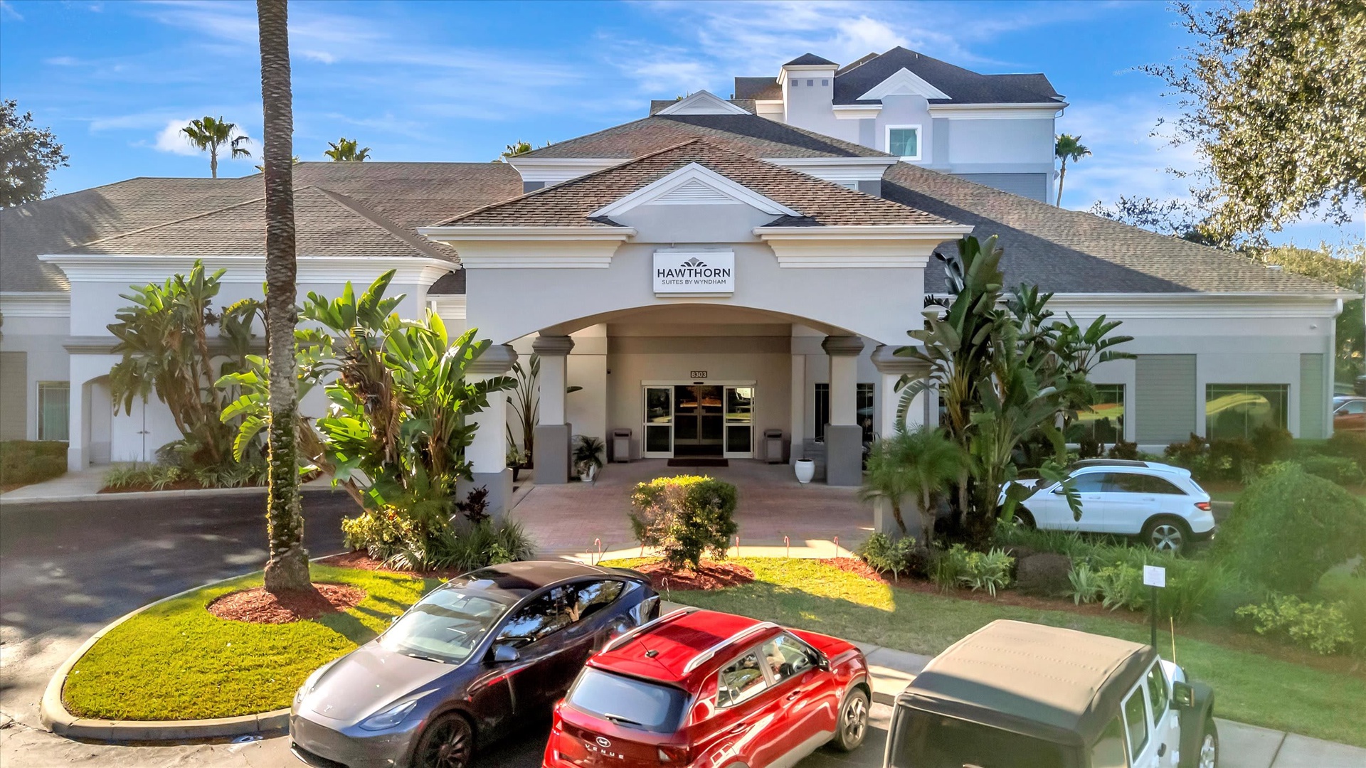 This is Hawthorn Suites, a well-maintained property featuring tropical landscaping and a welcoming arched entrance.