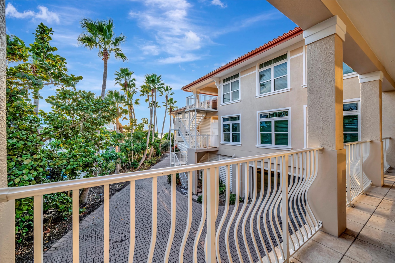 Scenic view from the property entrance area showcasing neighboring residential homes and lush palm trees that define the tropical coastal neighborhood.