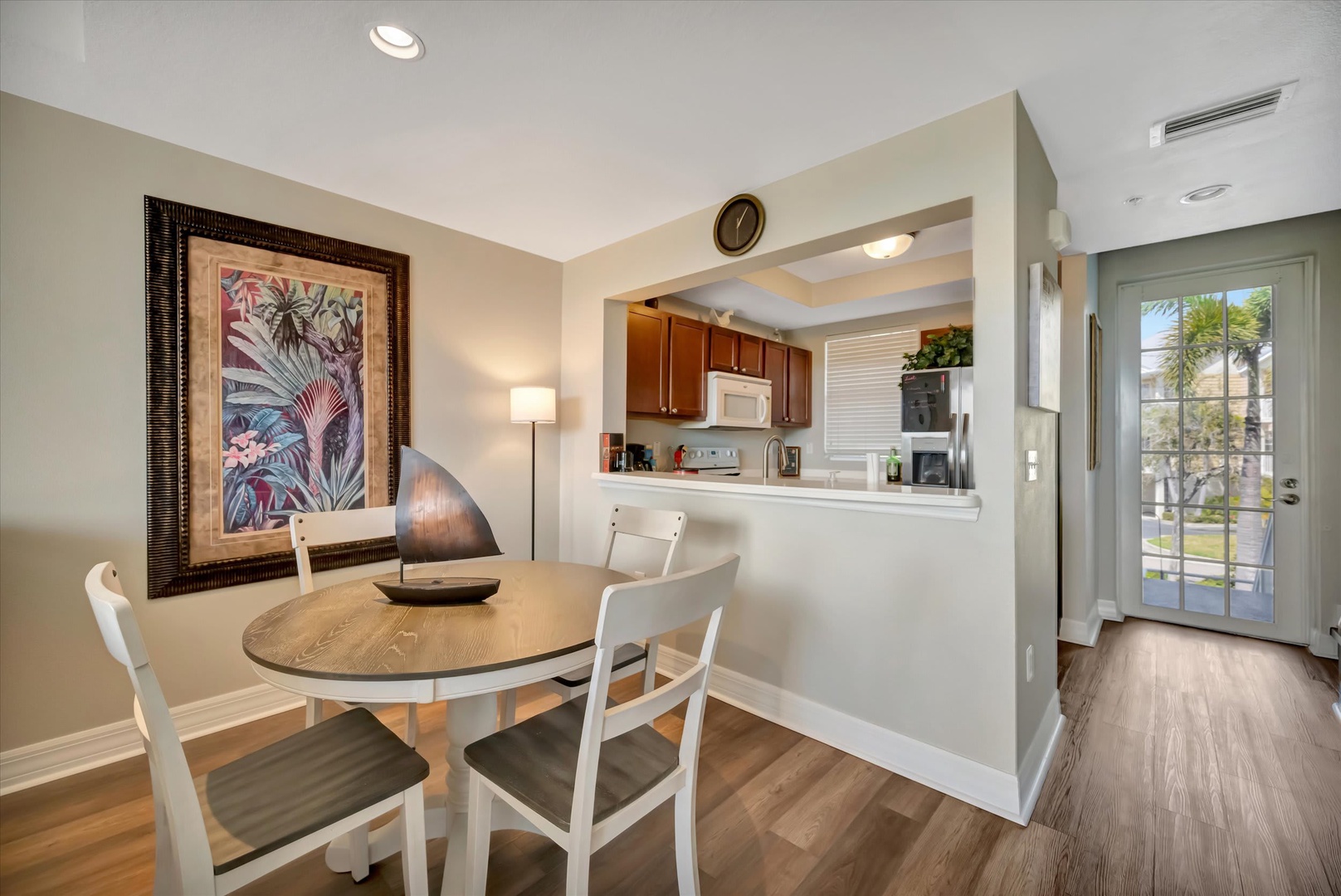 Step into your bright and inviting dining space, where natural light welcomes you through the entry, and a cozy kitchen awaits just beyond the pass-through—perfect for easy meal prep and relaxed mornings.