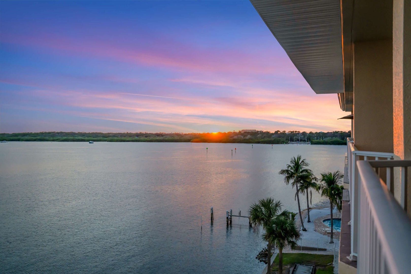 Watch the sunset paint the sky in brilliant hues from your private balcony, where peaceful water views and swaying palms create the perfect backdrop for your evening unwind.