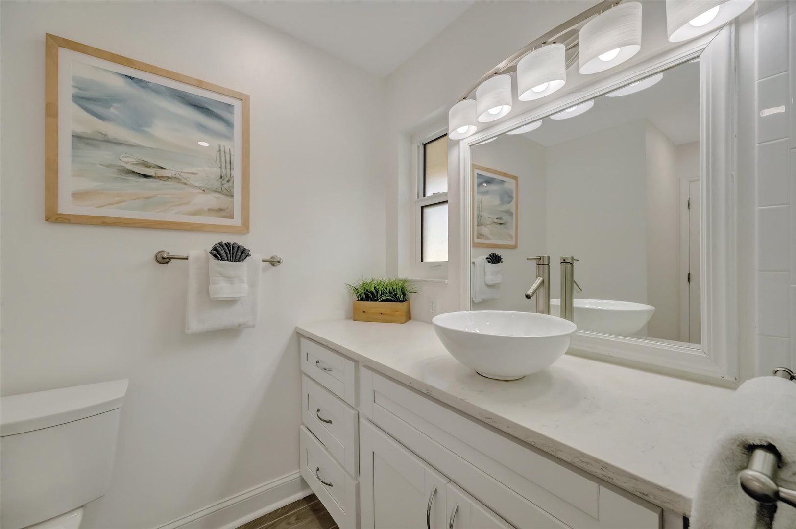 Step into your spa-like bathroom with coastal charm. Soft lighting, a sleek vessel sink, and thoughtful touches create a bright, calming space where you can unwind after a day of exploring.