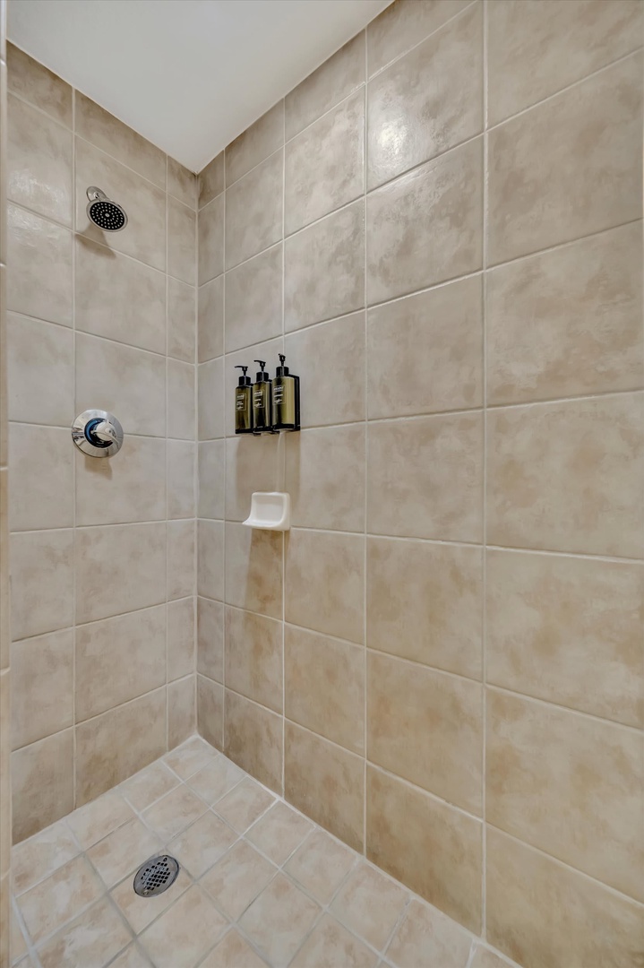 Step into your private tiled shower, where warm water and premium amenities await after a day of exploring. The built-in niche keeps everything you need within easy reach.