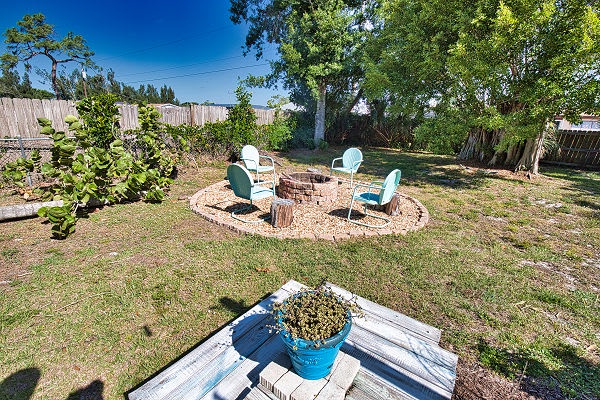 Step into your private backyard oasis with a shaded seating area perfect for morning coffee or evening stargazing under mature trees. The fenced yard offers seclusion and space to unwind.