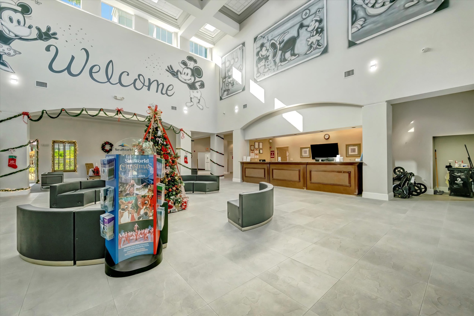 A bright, welcoming lobby featuring vintage character artwork and a festive holiday Christmas tree—setting the tone for your vacation adventure from the moment you arrive.