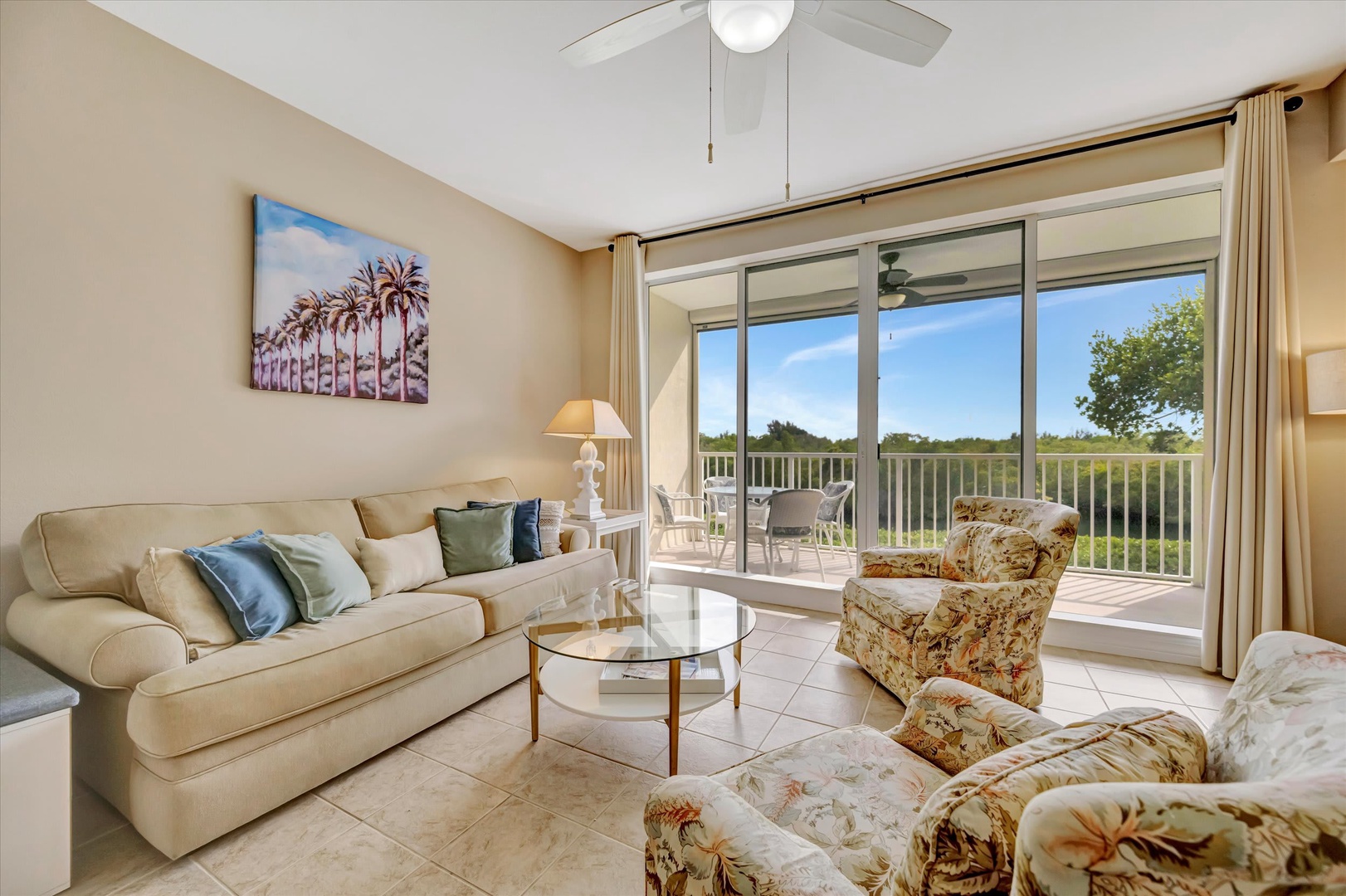 Settle into this cozy living room where soft, natural light and gentle breezes flow through the doors. Sink into the plush sofa, unwind with your favorite book, and let the peaceful greenery beyond become your daily backdrop.