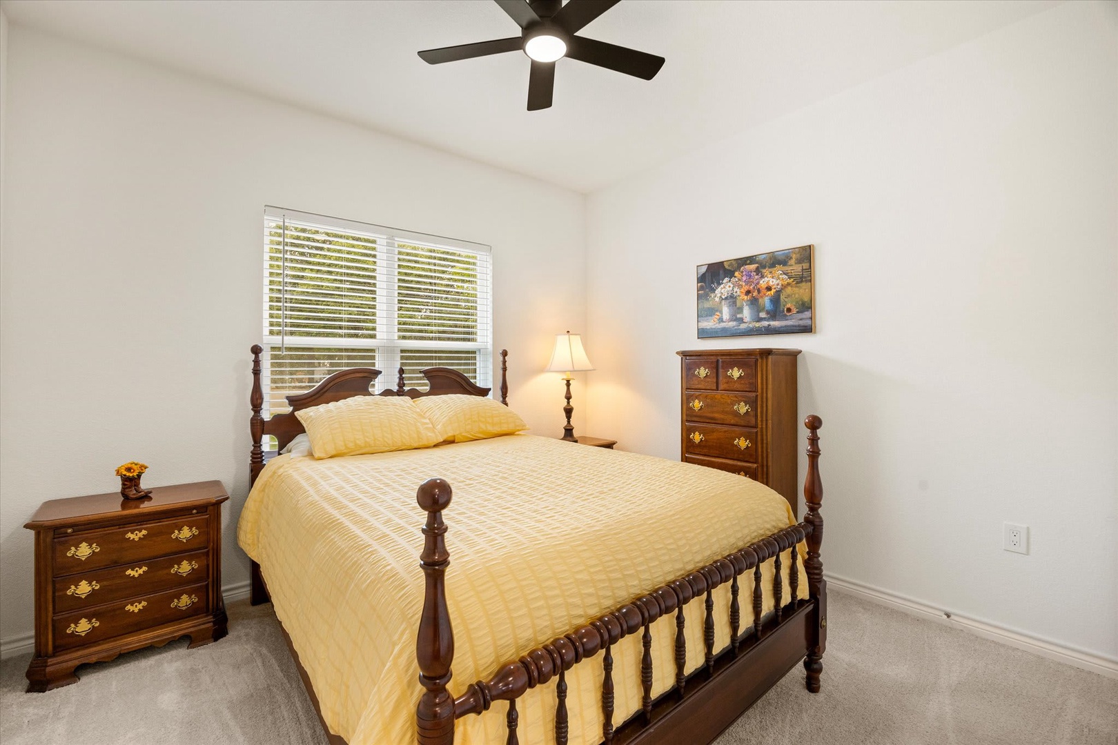 Your cozy bedroom awaits with a comfortable bed dressed in soft linens, classic wooden furniture for your belongings, and gentle natural light filtered through plantation shutters to help you unwind.