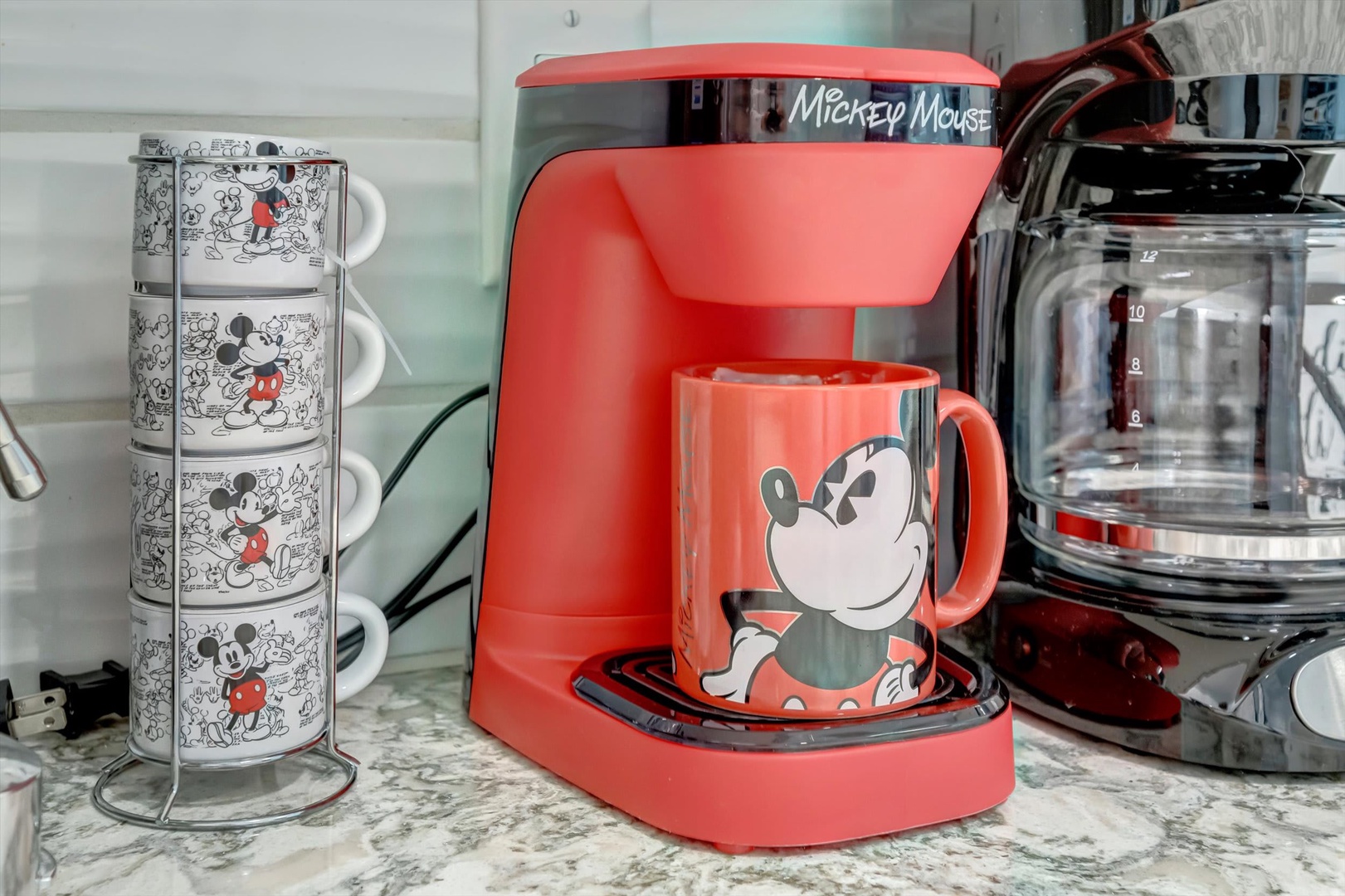Your morning coffee routine gets a playful upgrade with this cheerful setup. The bright red coffee maker and matching mug bring personality to your countertop, making every brew a little more fun.
