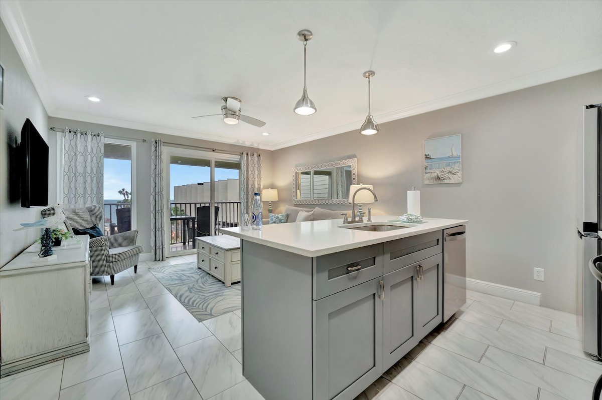 Your open-concept space flows effortlessly from kitchen to living area, where ocean breezes drift through the balcony and modern comforts await your arrival.