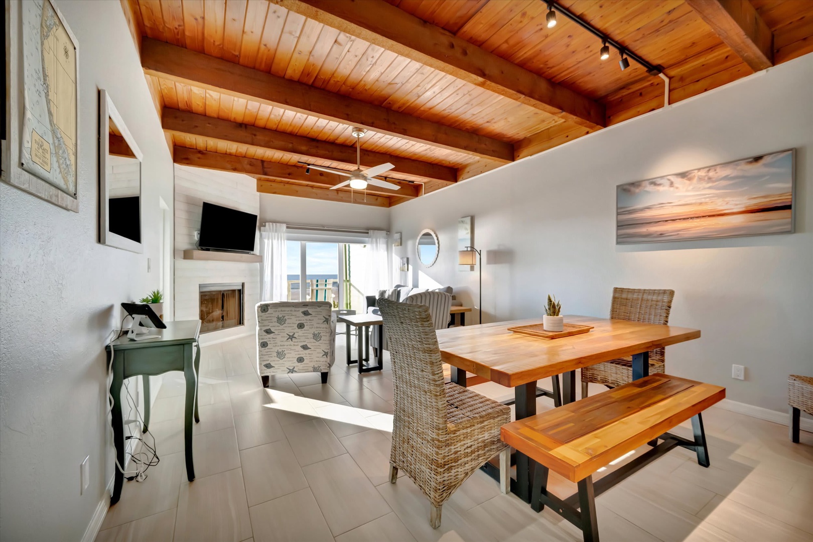 Gather around your private dining table beneath warm wood beam ceilings that invite relaxed meals and conversation. Natural light fills the open space, connecting you to the living area and balcony beyond.