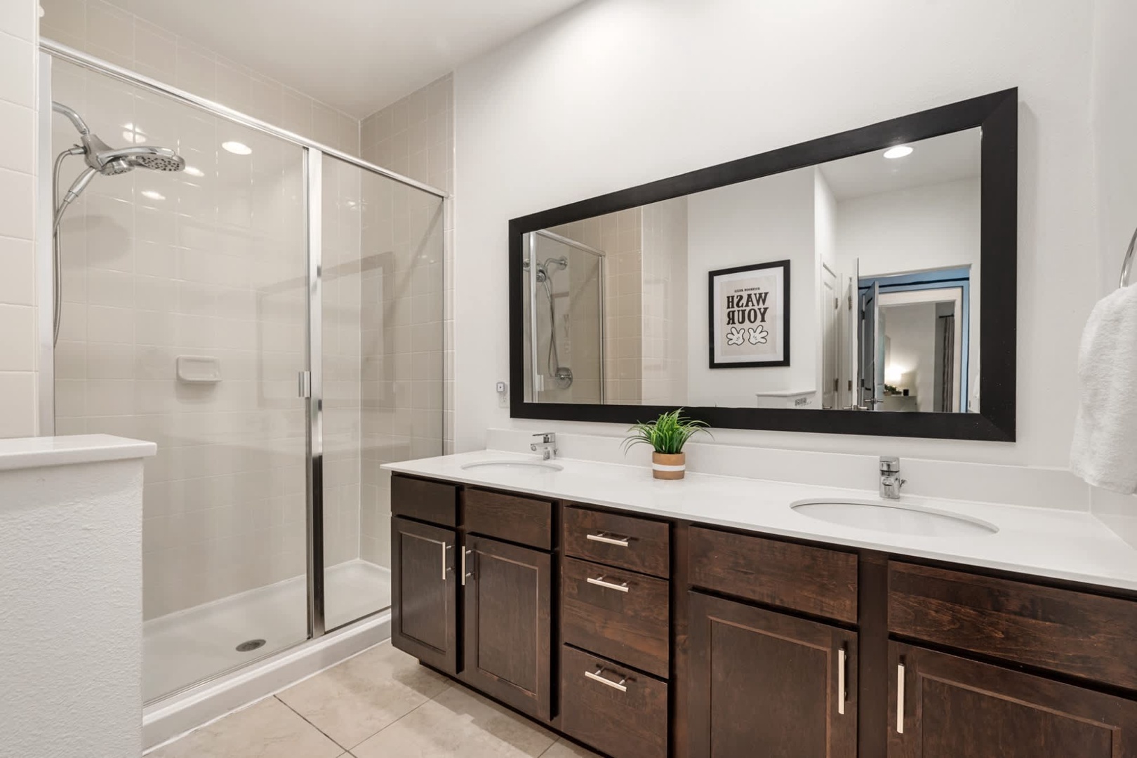 Step into your spa-inspired ensuite with dual vanities, gleaming countertops, and a spacious walk-in shower—your private retreat after a day of adventure.