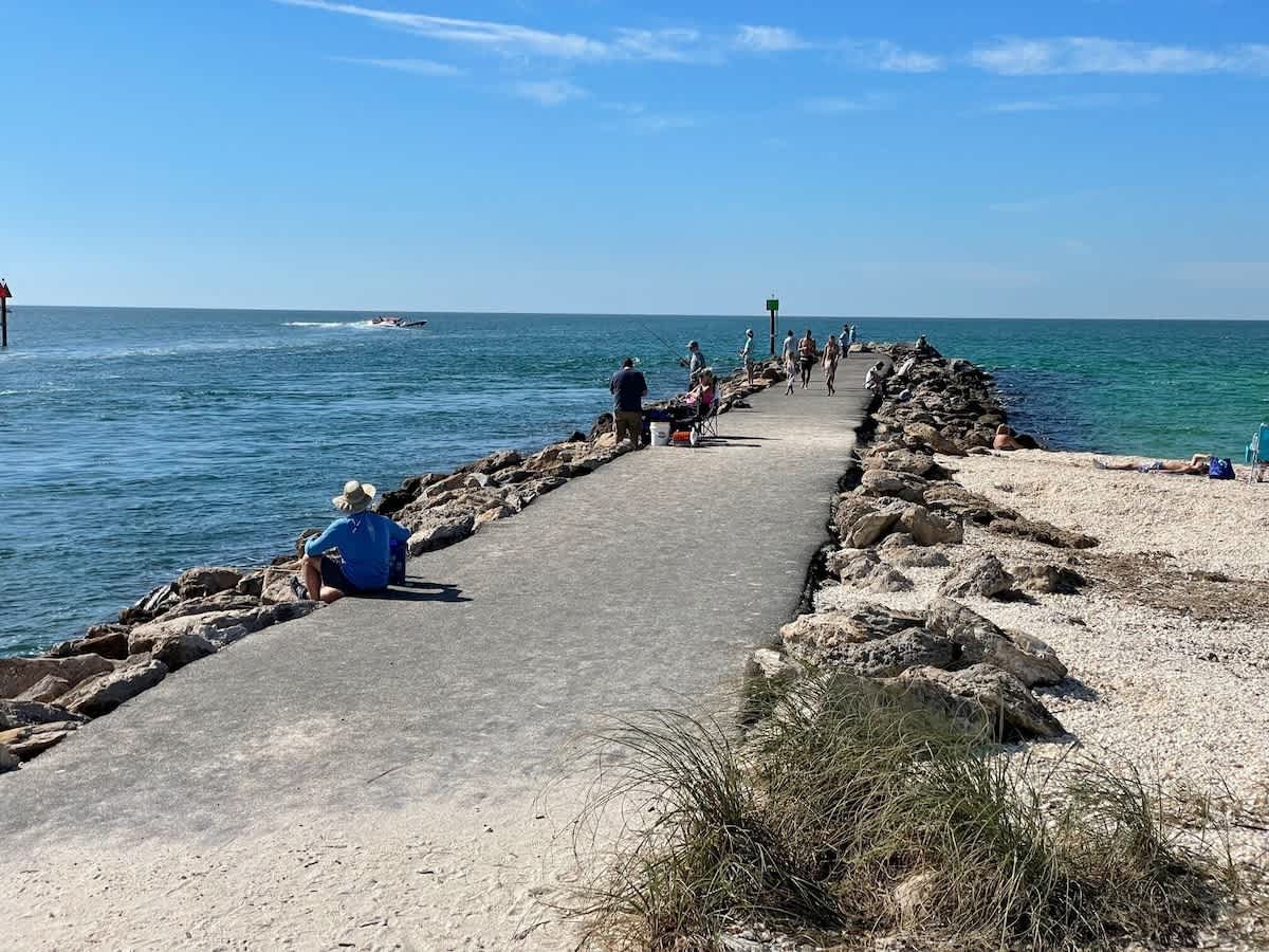 A scenic jetty stretches into turquoise waters, offering perfect spots for fishing and waterfront strolls in the surrounding area.