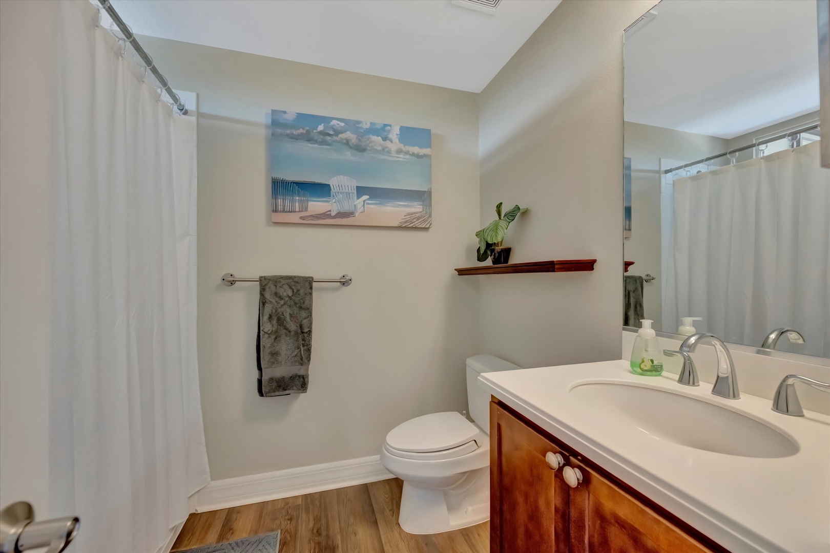 Step into your private bathroom where soft tones and coastal touches create a serene escape. The spacious shower and dual-sink vanity promise convenience, while warm wood accents add a welcoming touch.