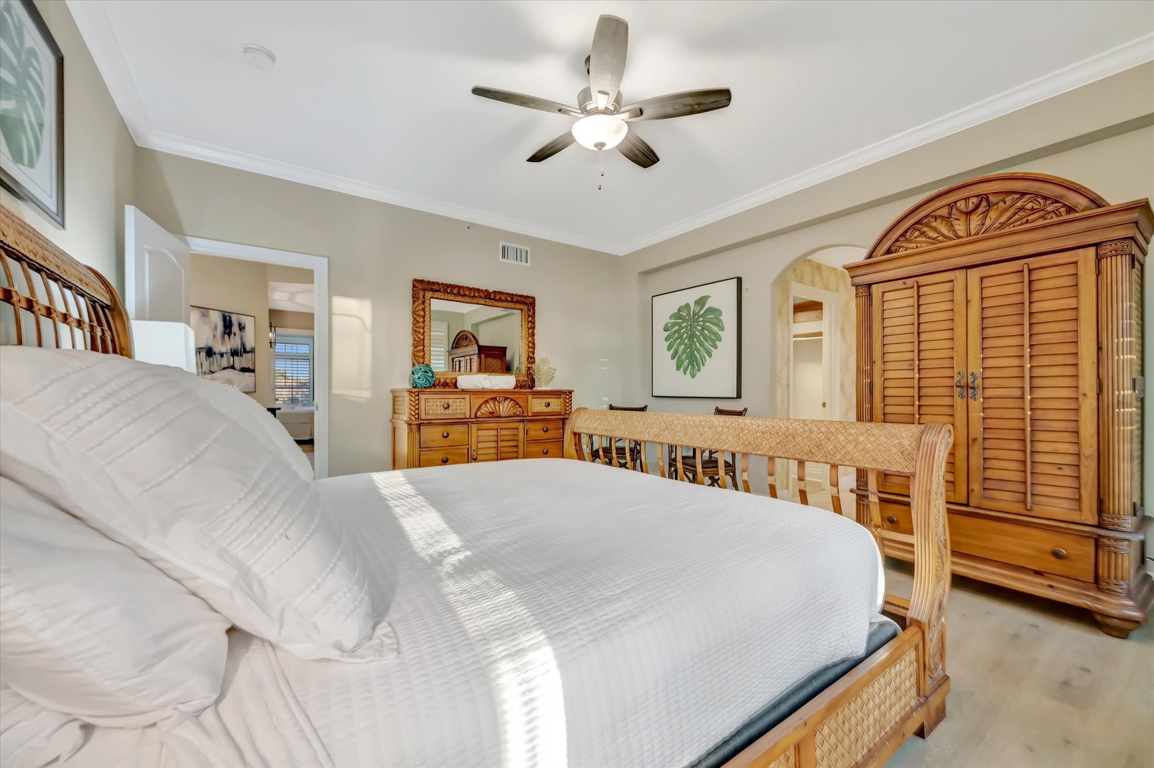 Relax in your spacious bedroom featuring crisp linens, tropical-inspired wood furniture, and a ceiling fan to keep you comfortable all night long.