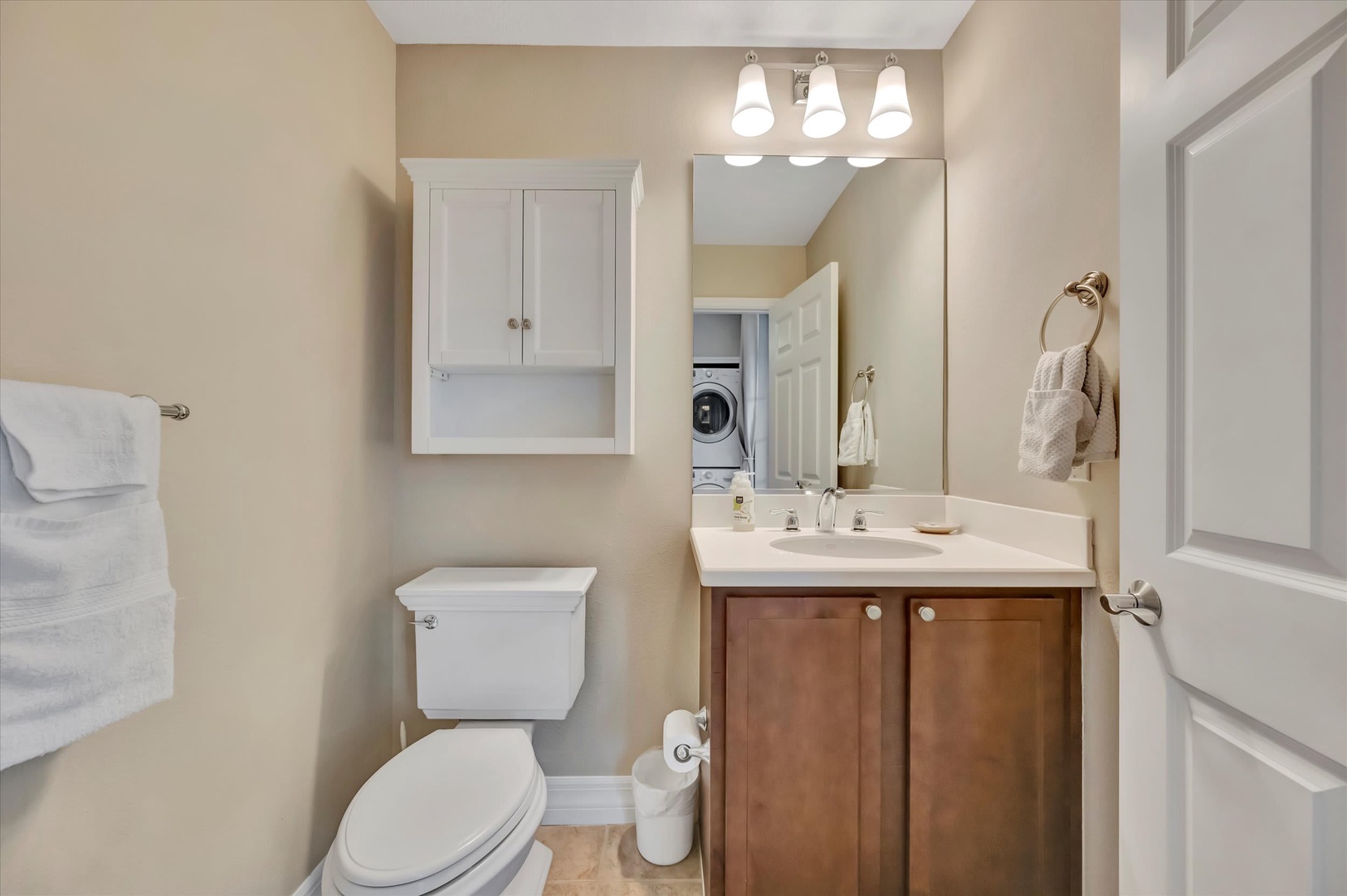 Step into a bright, freshly updated bathroom with warm tones and thoughtful details. Plush towels await, and you'll love the convenient in-unit laundry just steps away—perfect for easy, carefree stays.