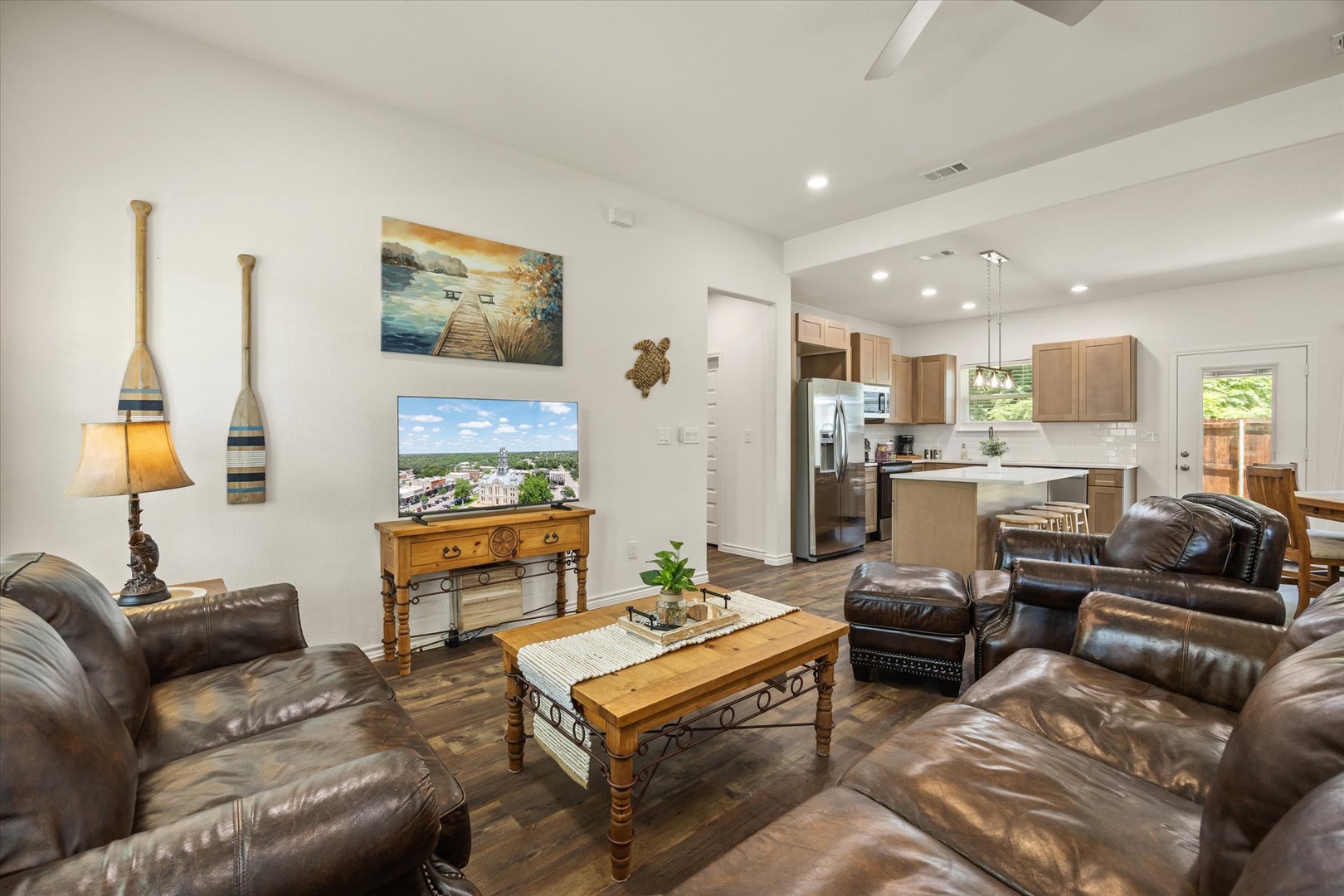 Settle into this inviting open-concept space where living, dining, and kitchen flow together seamlessly. The rich leather seating and warm wood accents create a welcoming retreat where you can unwind after exploring the area.