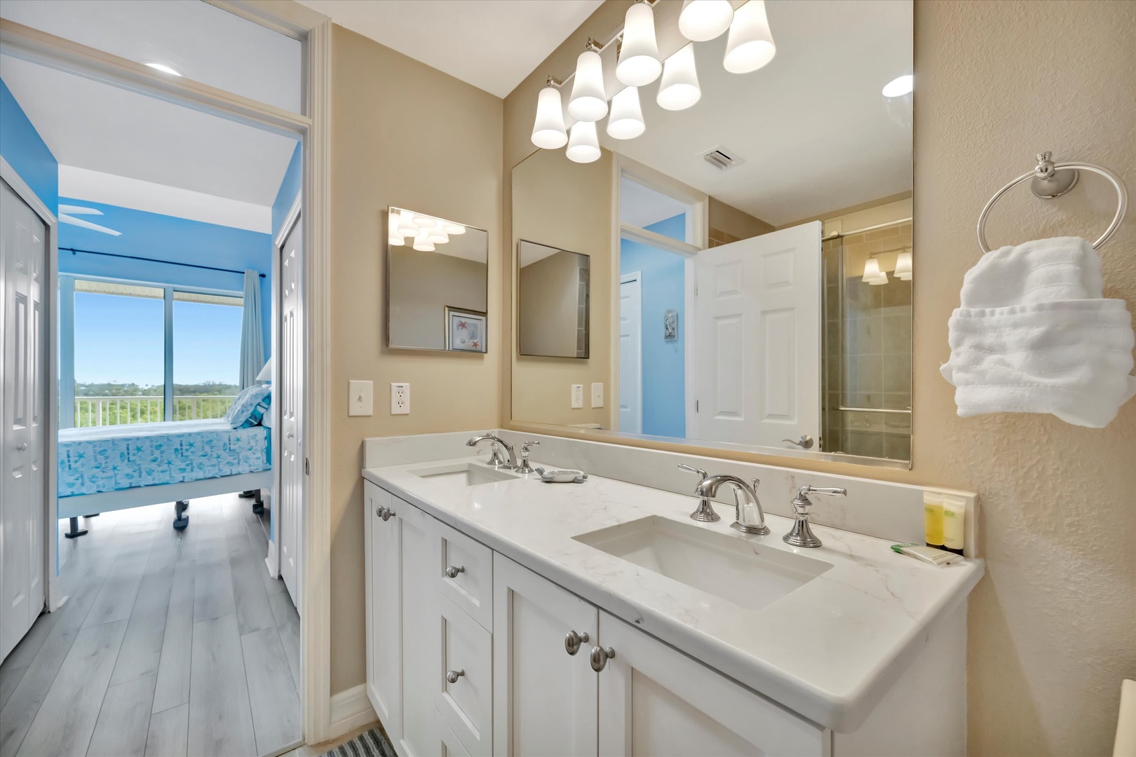 Start your day refreshed in this bright dual-vanity bathroom, where soft natural light flows in from the adjoining bedroom. You'll love the plush towels, gleaming fixtures, and modern finishes that make getting ready feel effortless.