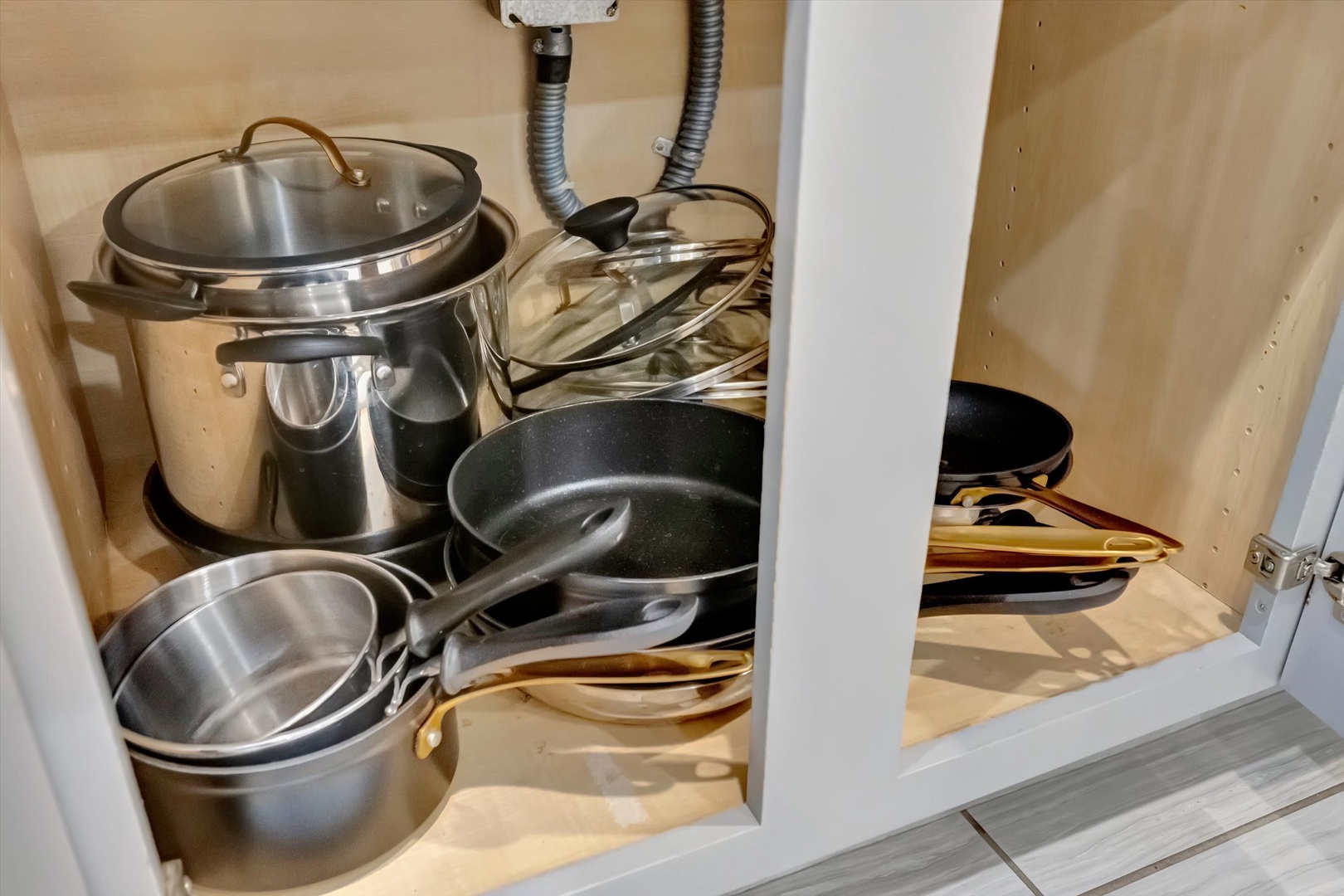 You'll find everything you need to cook up delicious meals in your well-stocked kitchen. This storage cabinet is packed with pots, pans, and cookware—all the essentials to feel right at home.