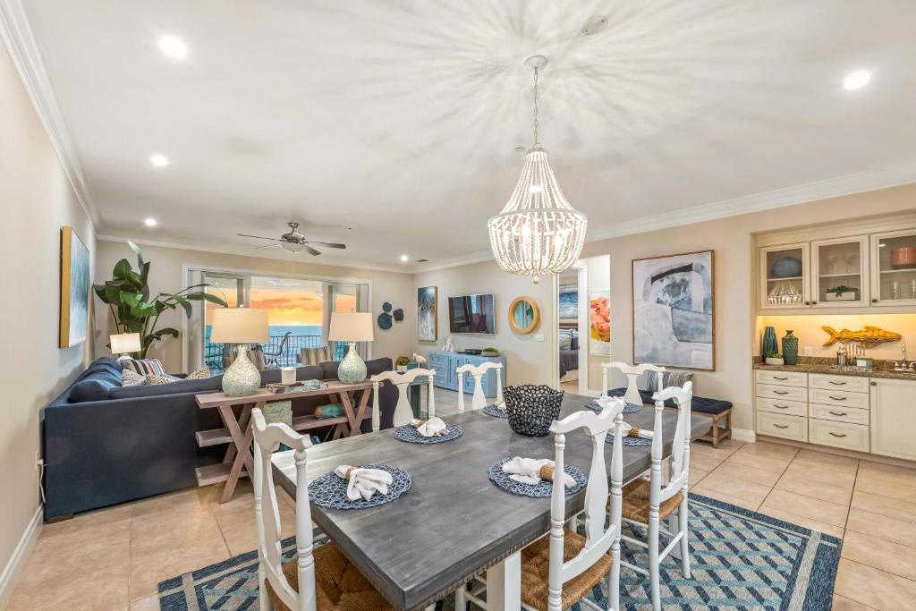 Settle into your beautifully styled retreat where coastal elegance meets relaxed comfort. Your open living and dining area invites effortless gathering, crowned by an elegant chandelier and framed by those stunning sunset views beyond your balcony.