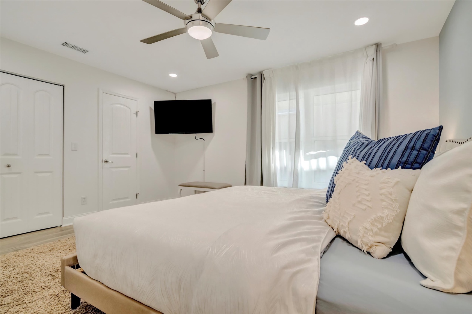 Slip into crisp linens and unwind in your bright, airy retreat. Gentle breezes from the ceiling fan, a cozy TV for lazy mornings, and soft natural light set the scene for total relaxation.