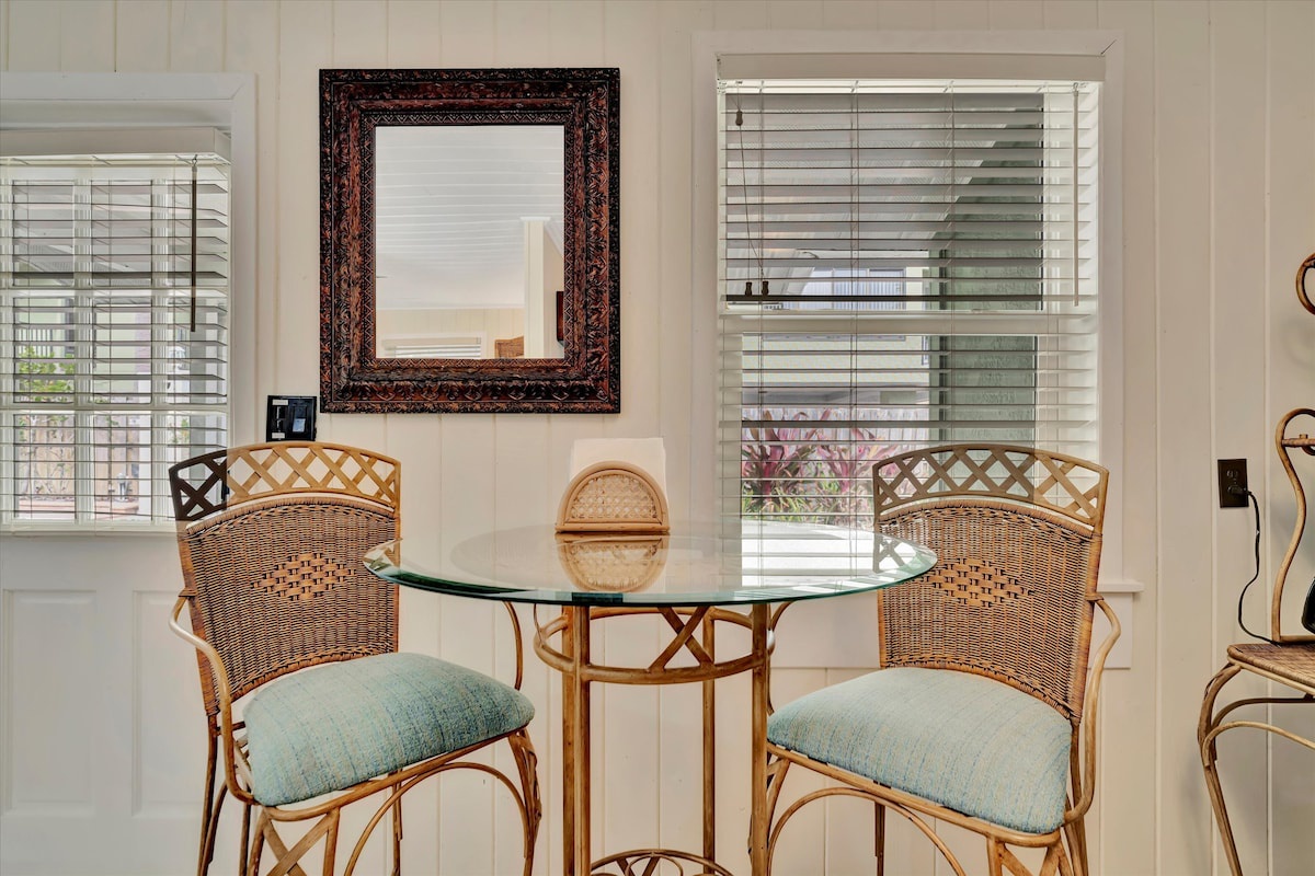Settle in at your cozy breakfast nook with morning coffee, framed by bright windows that invite natural light and a serene garden view just beyond.