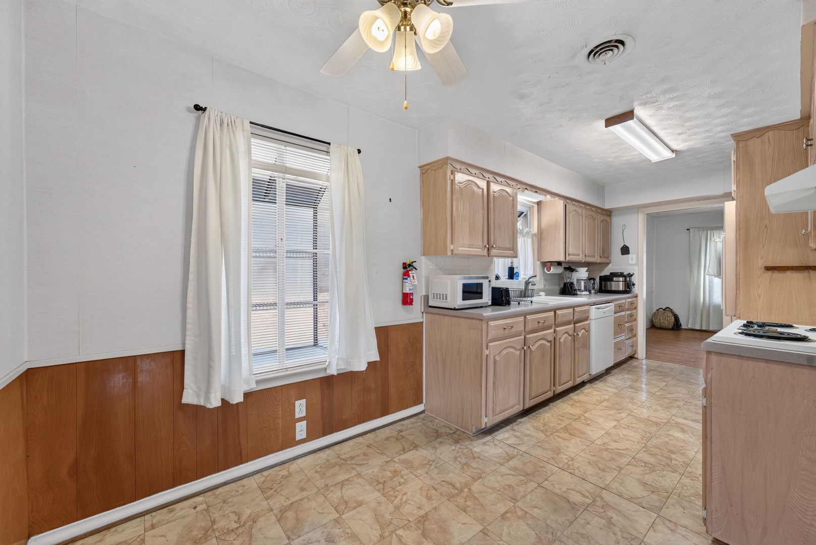 Step into a spacious kitchen with all the room you need to whip up your favorite meals, featuring classic wood cabinetry, ample counter space, and a bright, open layout that makes cooking feel like home.