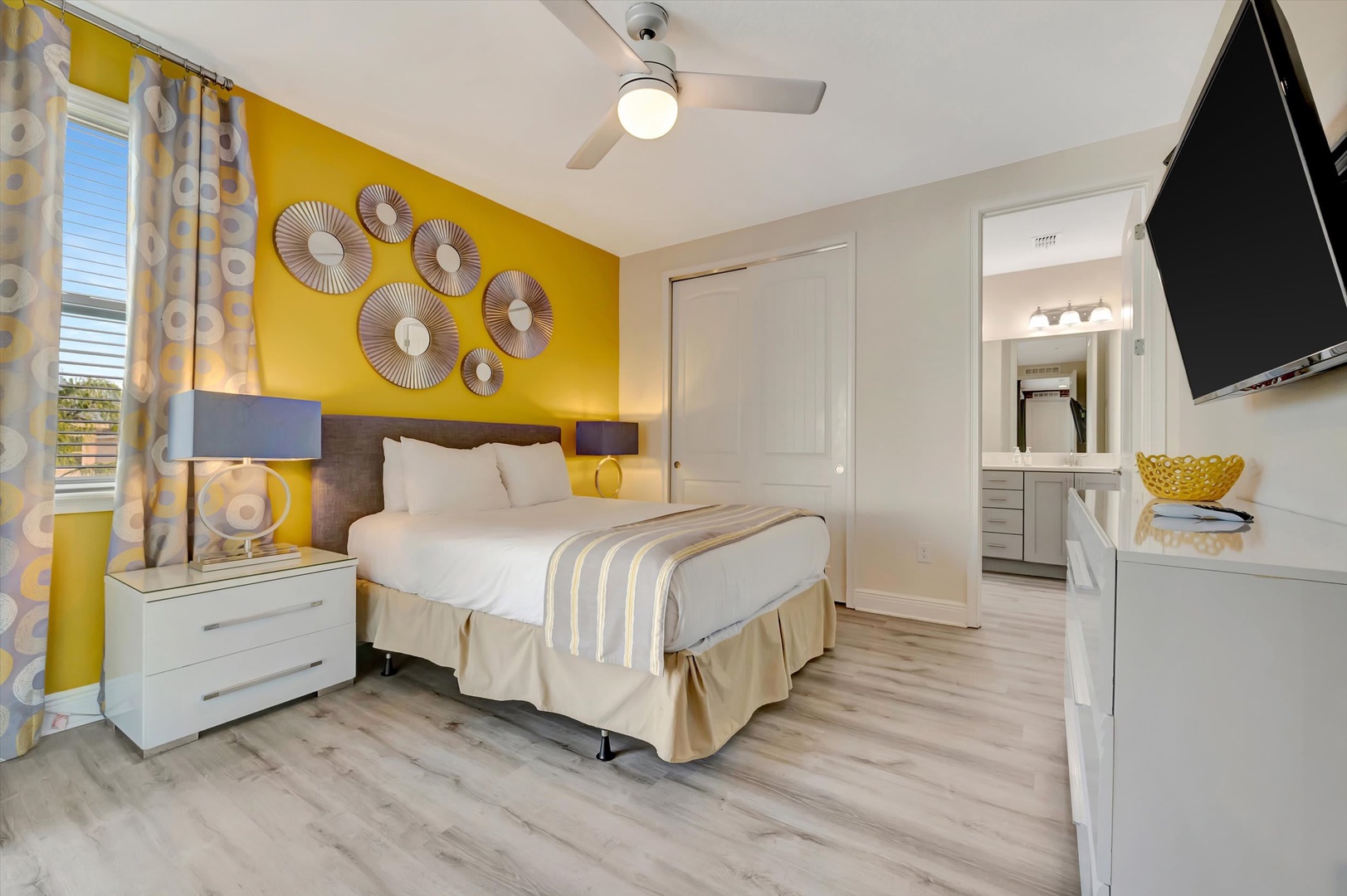 Sink into plush linens and let the vibrant yellow accent wall energize your mornings. Your bedroom offers a ceiling fan for warm nights, an ensuite bath steps away, and a smart TV for relaxing evenings in.